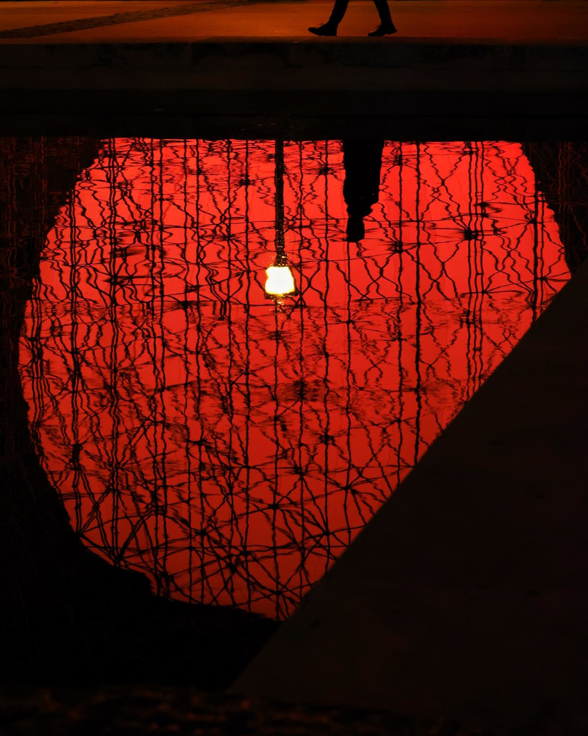 Tierra/Earth. A luminous red sphere caged inside a structure